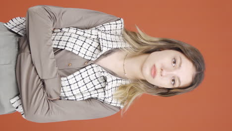 Vertical-video-of-Young-woman-looking-at-camera-with-dull-expression.